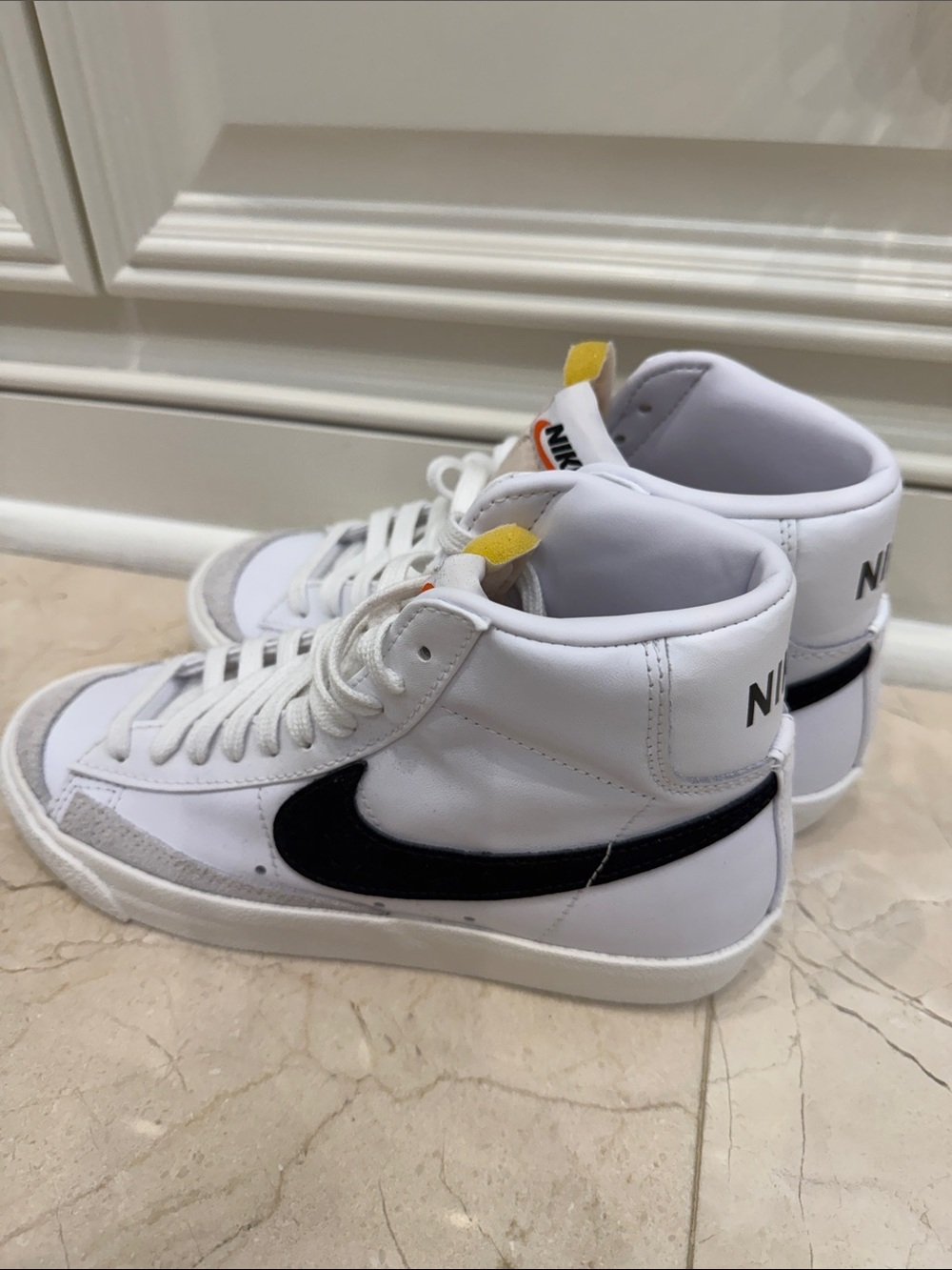 Nike White High-Top Sneakers with Black Swoosh and Yellow Tongue Tab